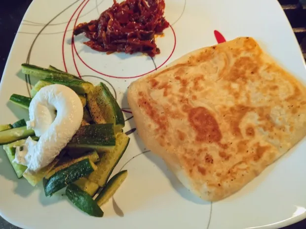 A paratha with sautéed courgette, a spoonful of yogurt and a little red chilli pickle