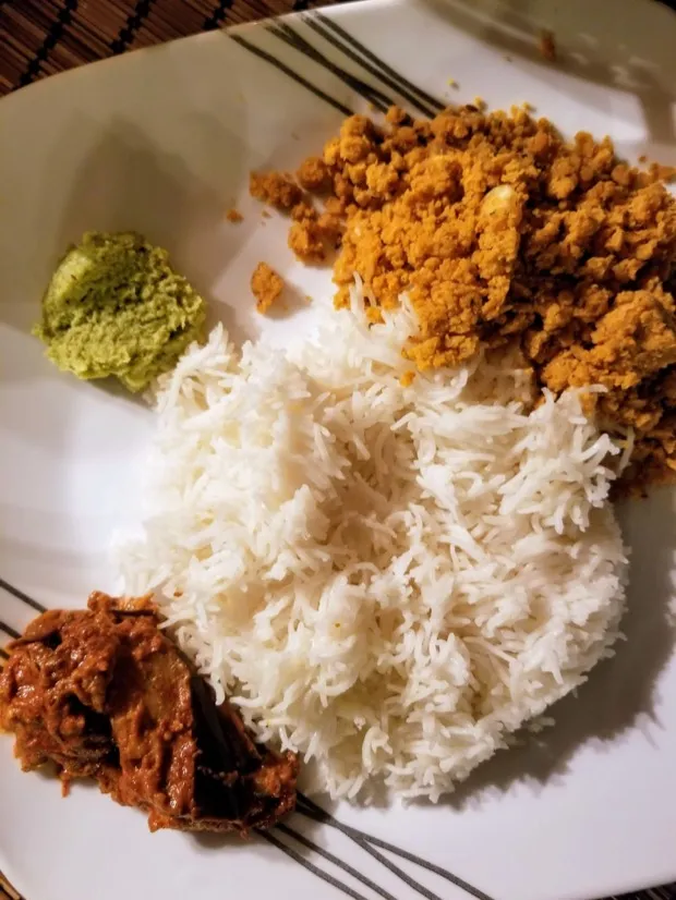 Steamed rice with a crumbly spiced podi, green coriander chutney and a spoonful of brinjal pickle